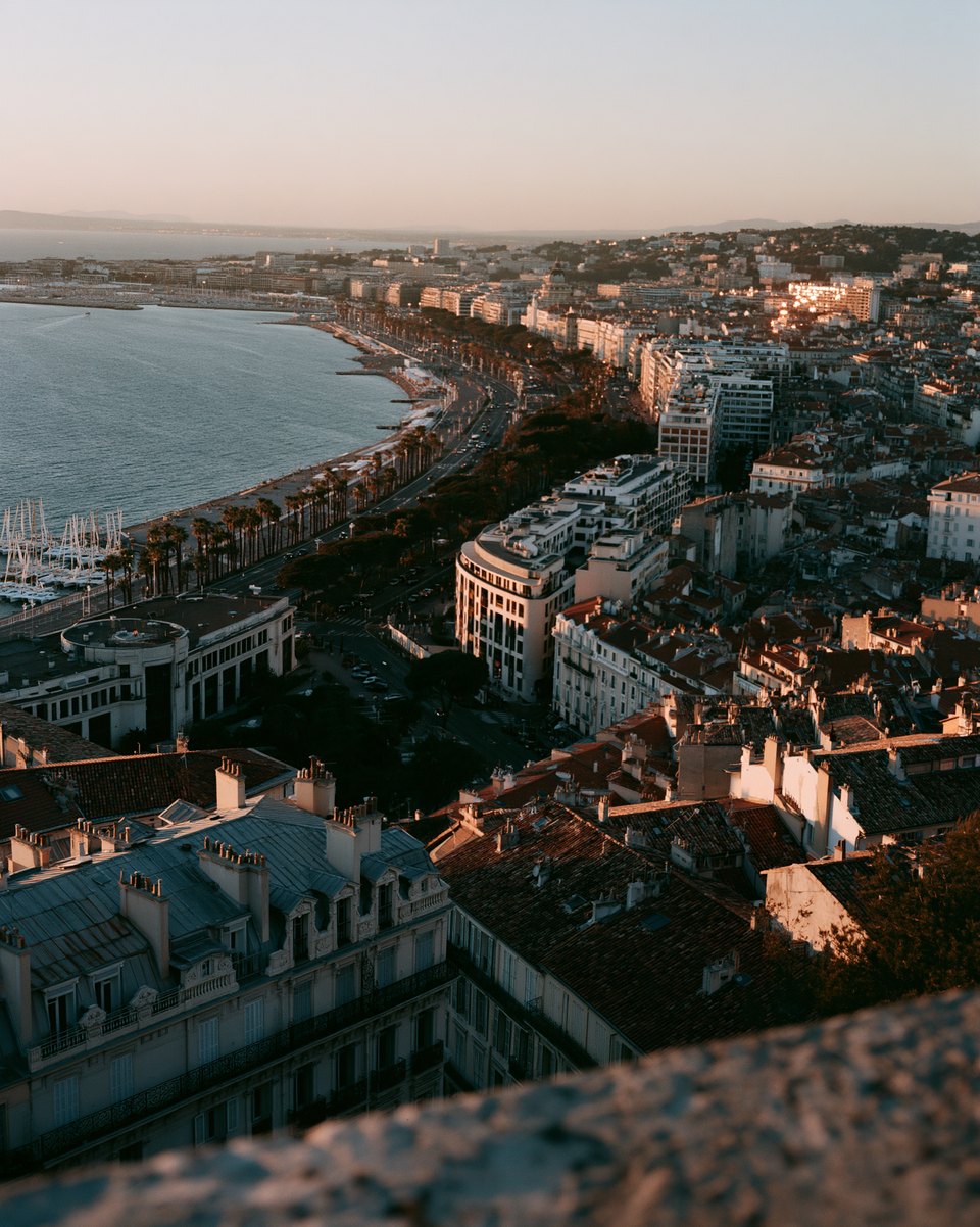 Seaside city at sunset seen from a rooftop edge